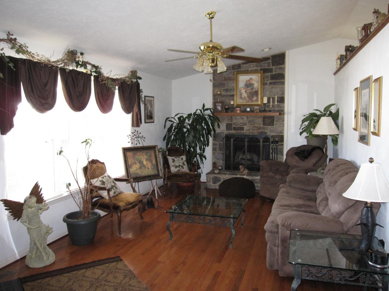 2169 Deep Woods Road Hardy, VA 24101 - Photo 25 of 37 a living room with furniture a fireplace and a chandelier