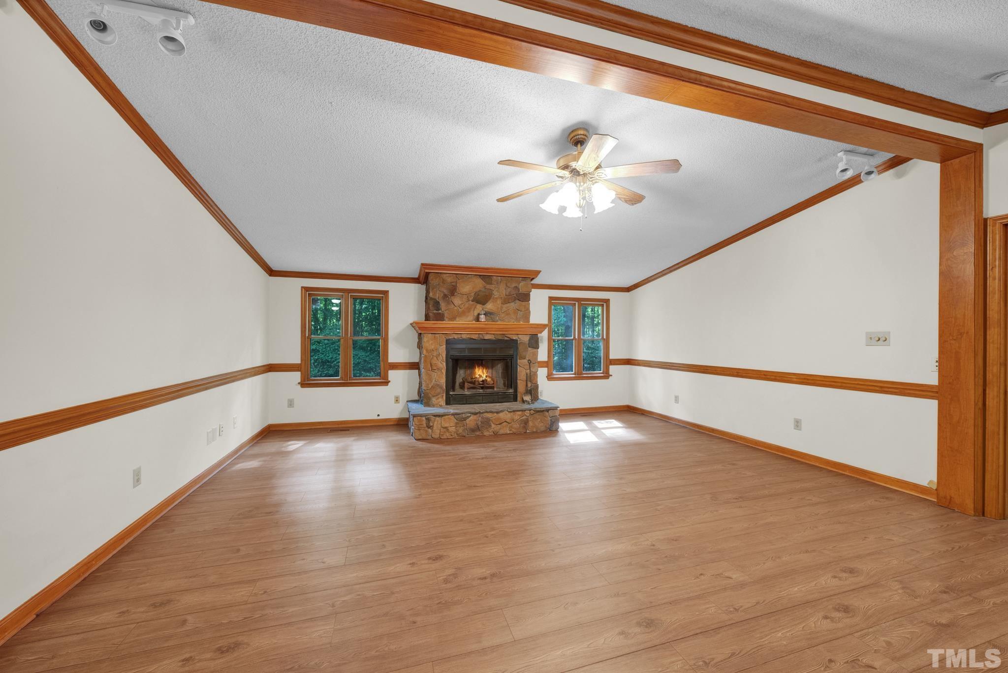 181 Simon Collie Road Louisburg, NC 27549 - Photo 12 of 26 a view of an empty room with a fireplace and a chandelier