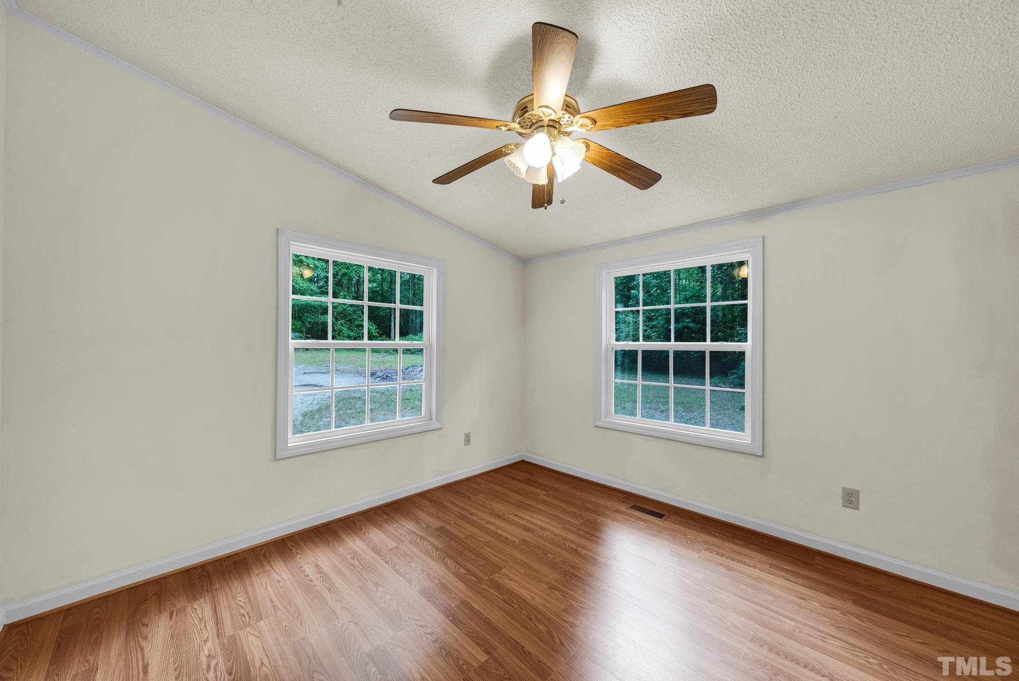 181 Simon Collie Road Louisburg, NC 27549 - Photo 19 of 26 an empty room with wooden floor fan and windows