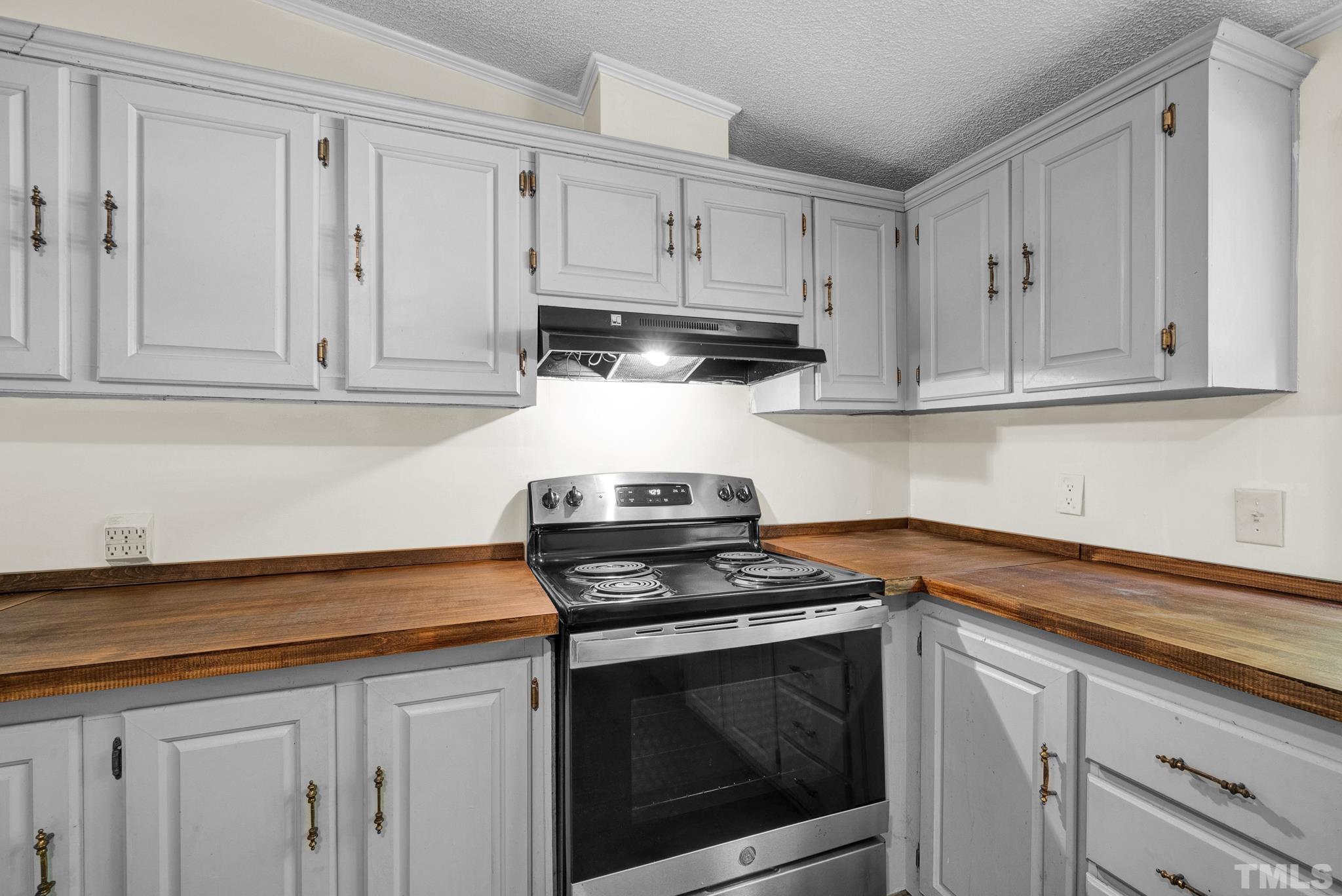 181 Simon Collie Road Louisburg, NC 27549 - Photo 5 of 26 a kitchen with granite countertop white cabinets and stainless steel appliances