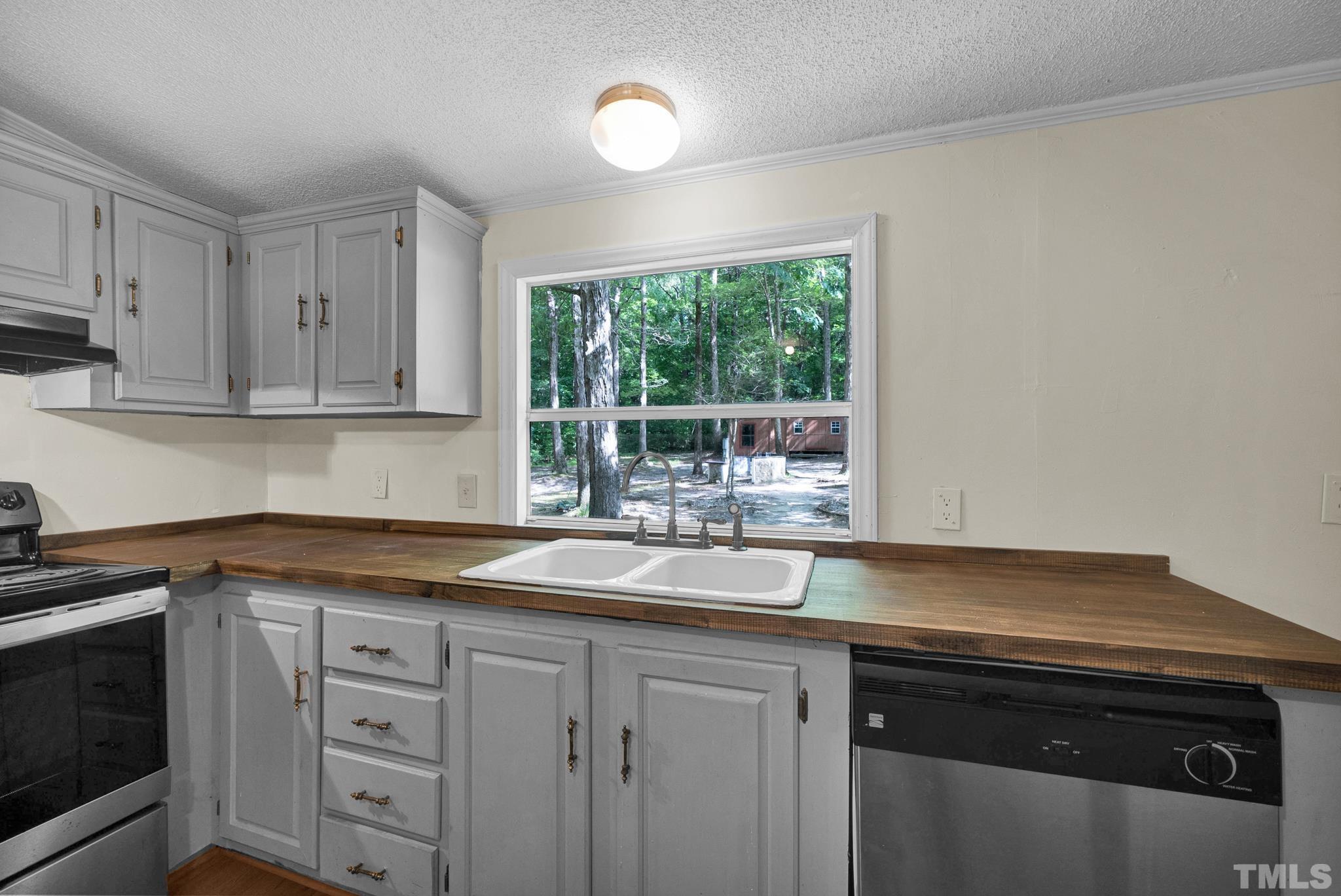 181 Simon Collie Road Louisburg, NC 27549 - Photo 6 of 26 a kitchen with granite countertop white cabinets white appliances and a sink