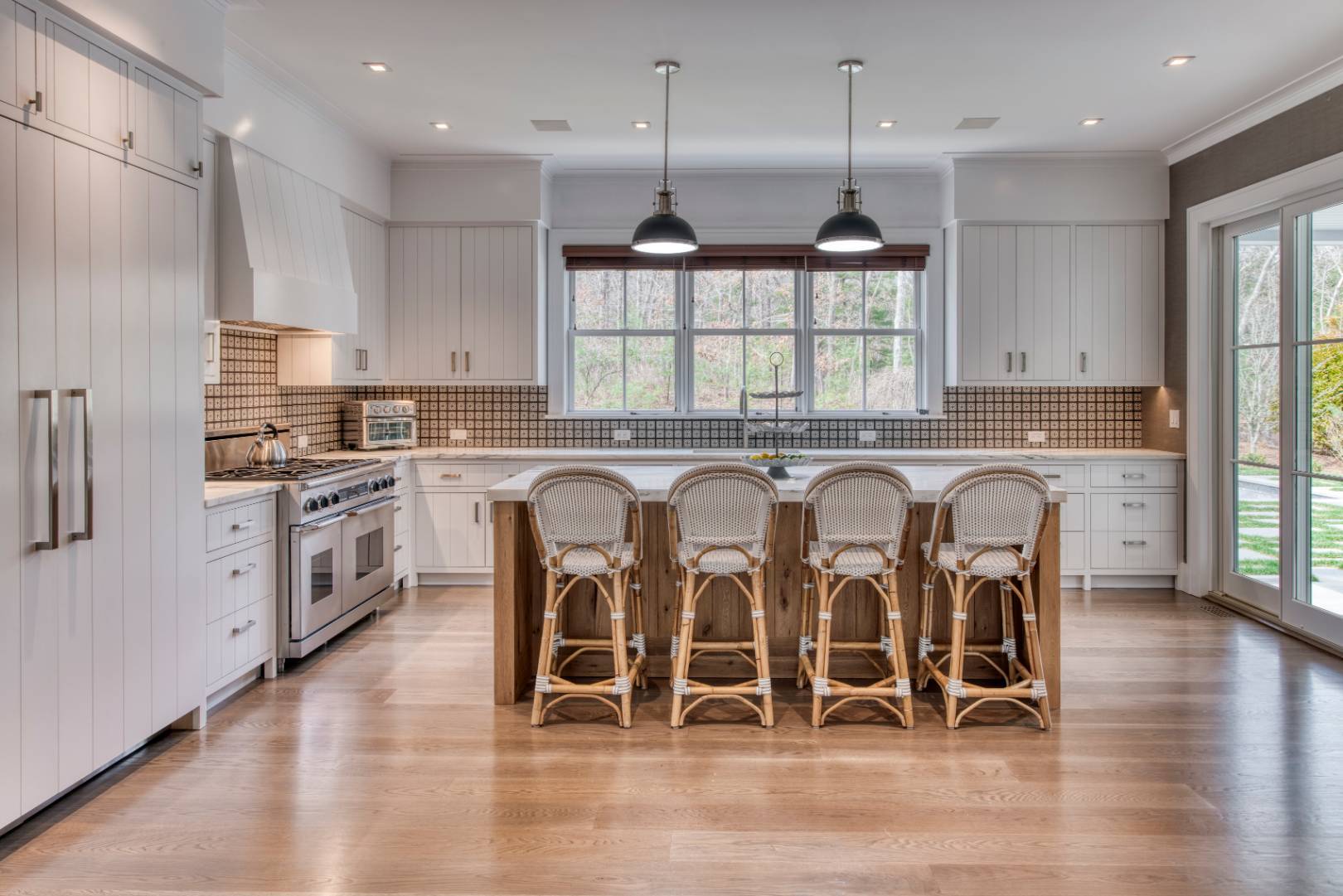 178 Bull Path East Hampton, NY 11937 - Photo 4 of 25 a kitchen with stainless steel appliances granite countertop a stove top oven a sink dishwasher a dining table and chairs with wooden floor