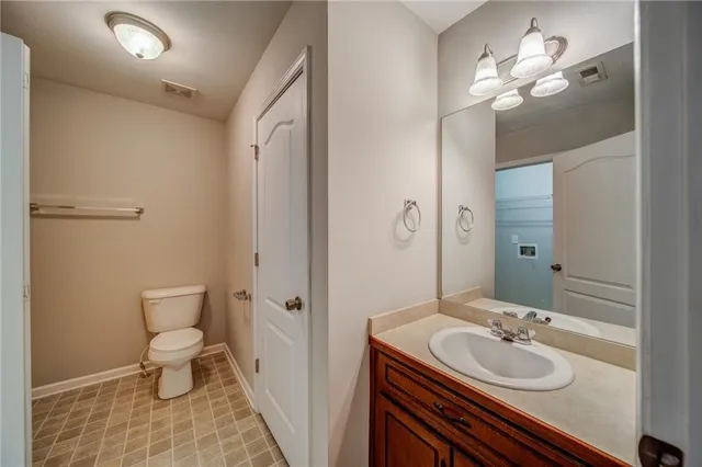 a bathroom with a sink a toilet a light fixture and a mirror
