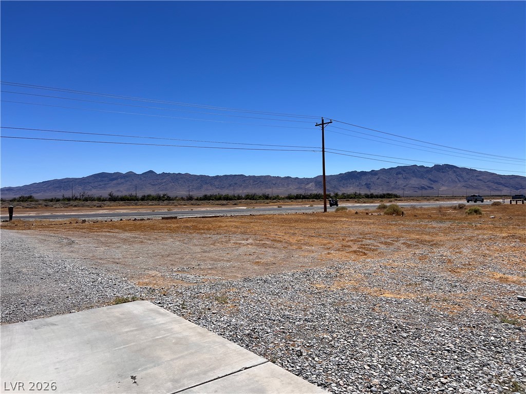 200 East Gamebird Road Pahrump, NV 89048 - Photo 23 of 23 A vast, open lot offering panoramic mountain views under a clear sky.