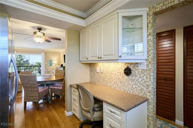 a room with a desk chairs and chandelier