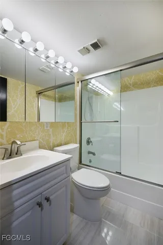 a bathroom with a sink a toilet a mirror and shower
