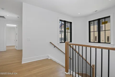 a view of a hallway with wooden floor and entryway