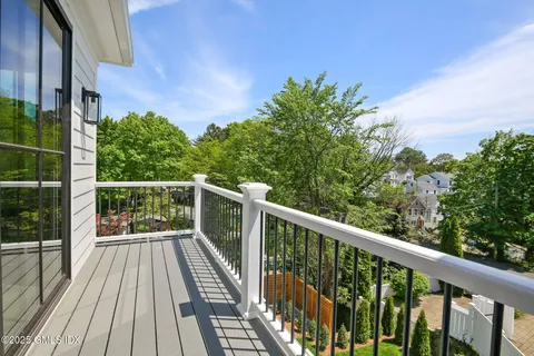 a view of balcony with wooden floor and fence