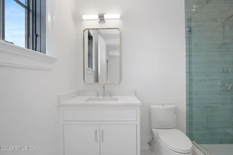 a bathroom with a toilet sink and mirror