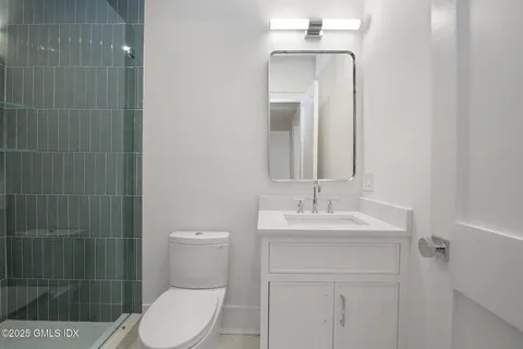 a bathroom with a toilet a sink and mirror