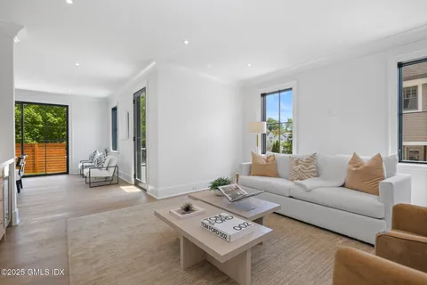 a living room with furniture a table and a large window