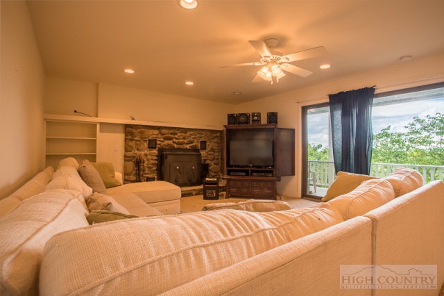 1115 Deck Hill Road Boone, NC 28607 - Photo 25 of 35 a living room with a couch a flat screen tv and a large window