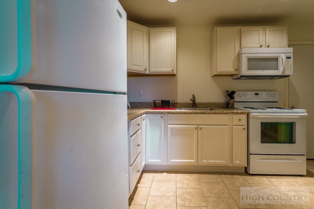 1115 Deck Hill Road Boone, NC 28607 - Photo 27 of 35 a kitchen with white cabinets and white appliances