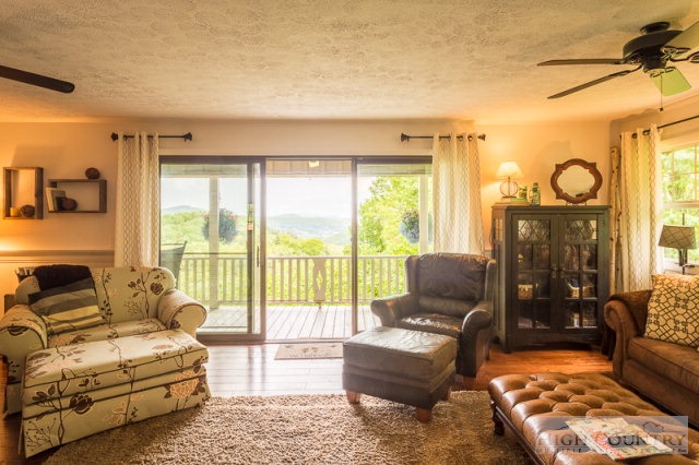 1115 Deck Hill Road Boone, NC 28607 - Photo 33 of 35 a living room with furniture and a floor to ceiling window