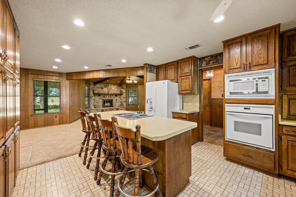 515 New Highland Road Springtown, TX 76082 - Photo 11 of 38 Kitchen featuring wood cabinetry, built-in wall oven and microwave, and a center island with a cooktop