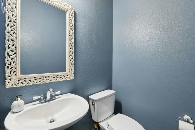 a bathroom with a toilet a sink and mirror