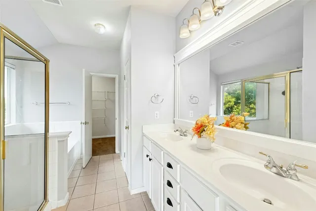 a spacious bathroom with a double vanity sink a mirror and shower