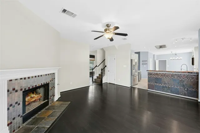 a view of an empty room with wooden floor and a fireplace