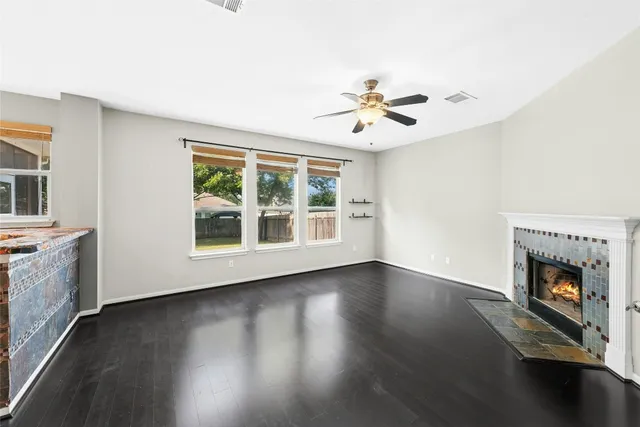 a view of an empty room with a fireplace and wooden floor