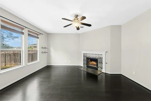 an empty room with windows and fireplace