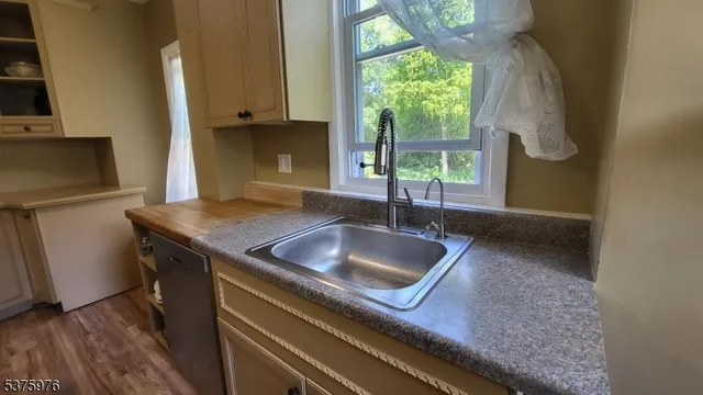 a living room with furniture and a large mirror next to a window