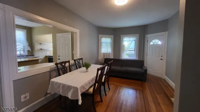 a view of a hallway with wooden floor and a flat screen tv