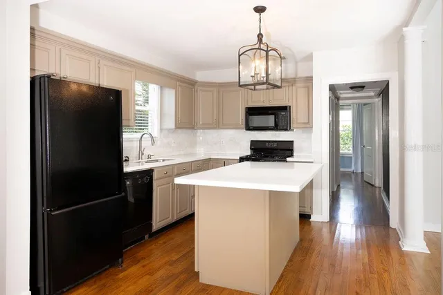 a kitchen with a refrigerator a stove cabinets and a wooden floor