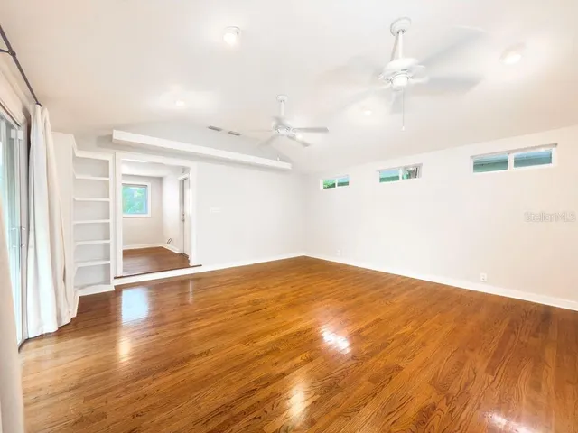 a view of empty room with wooden floor