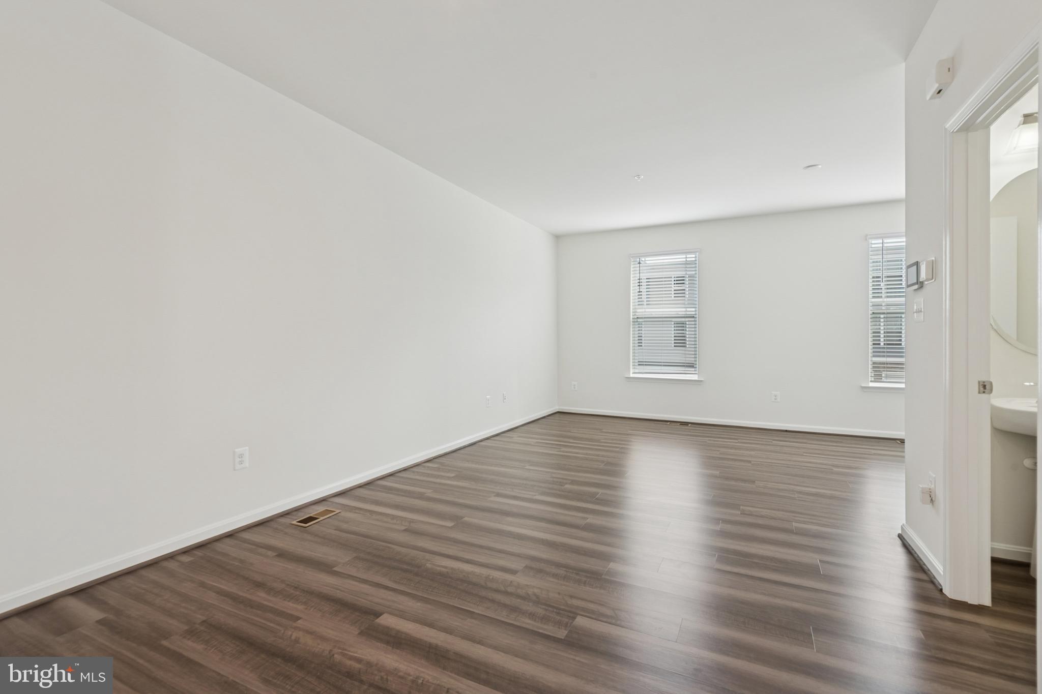 7831 Wolf Run Lane Severn, MD 21144 - Photo 12 of 30 a view of an empty room with wooden floor and a window