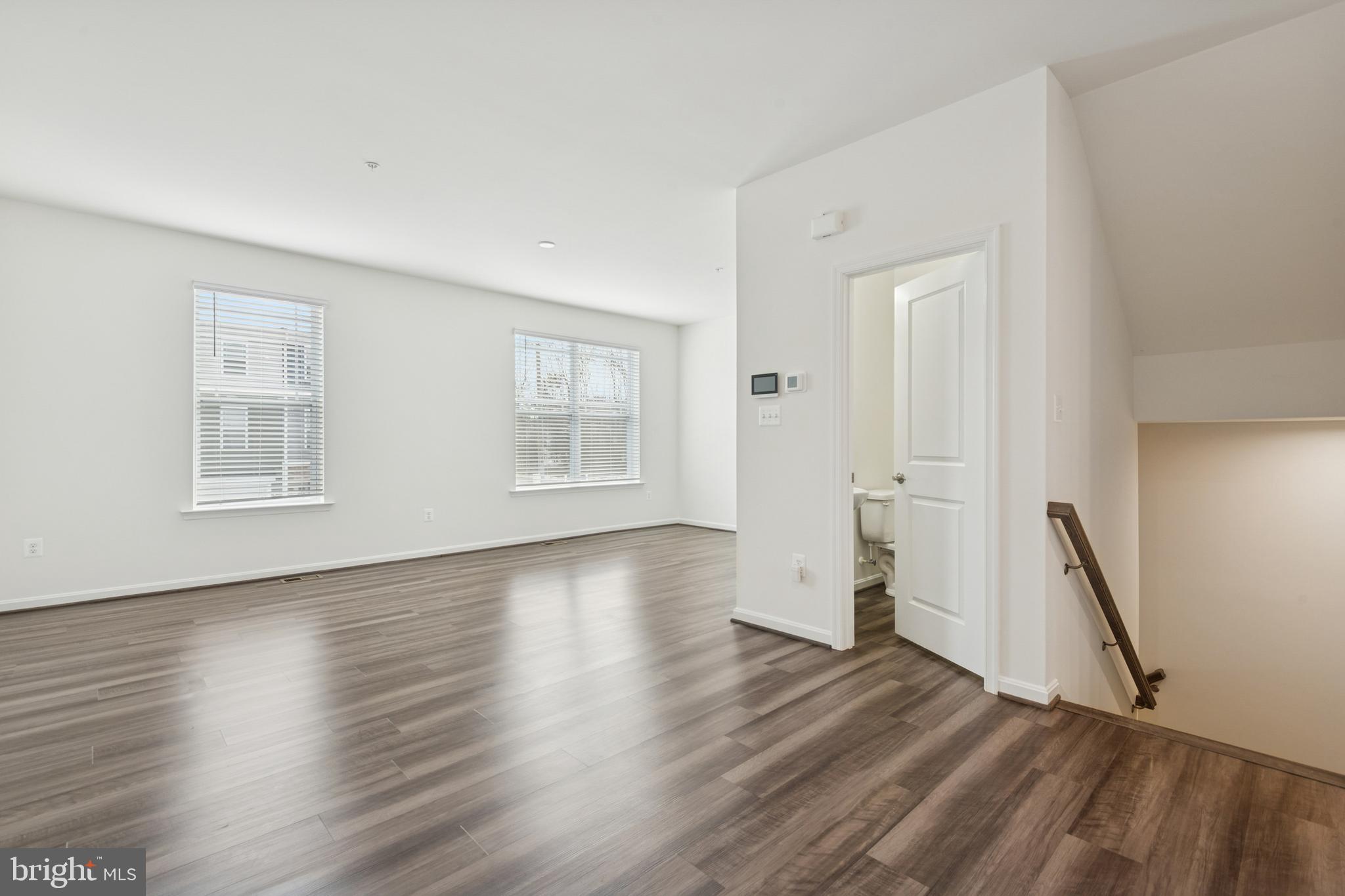 7831 Wolf Run Lane Severn, MD 21144 - Photo 13 of 30 an empty room with wooden floor and windows