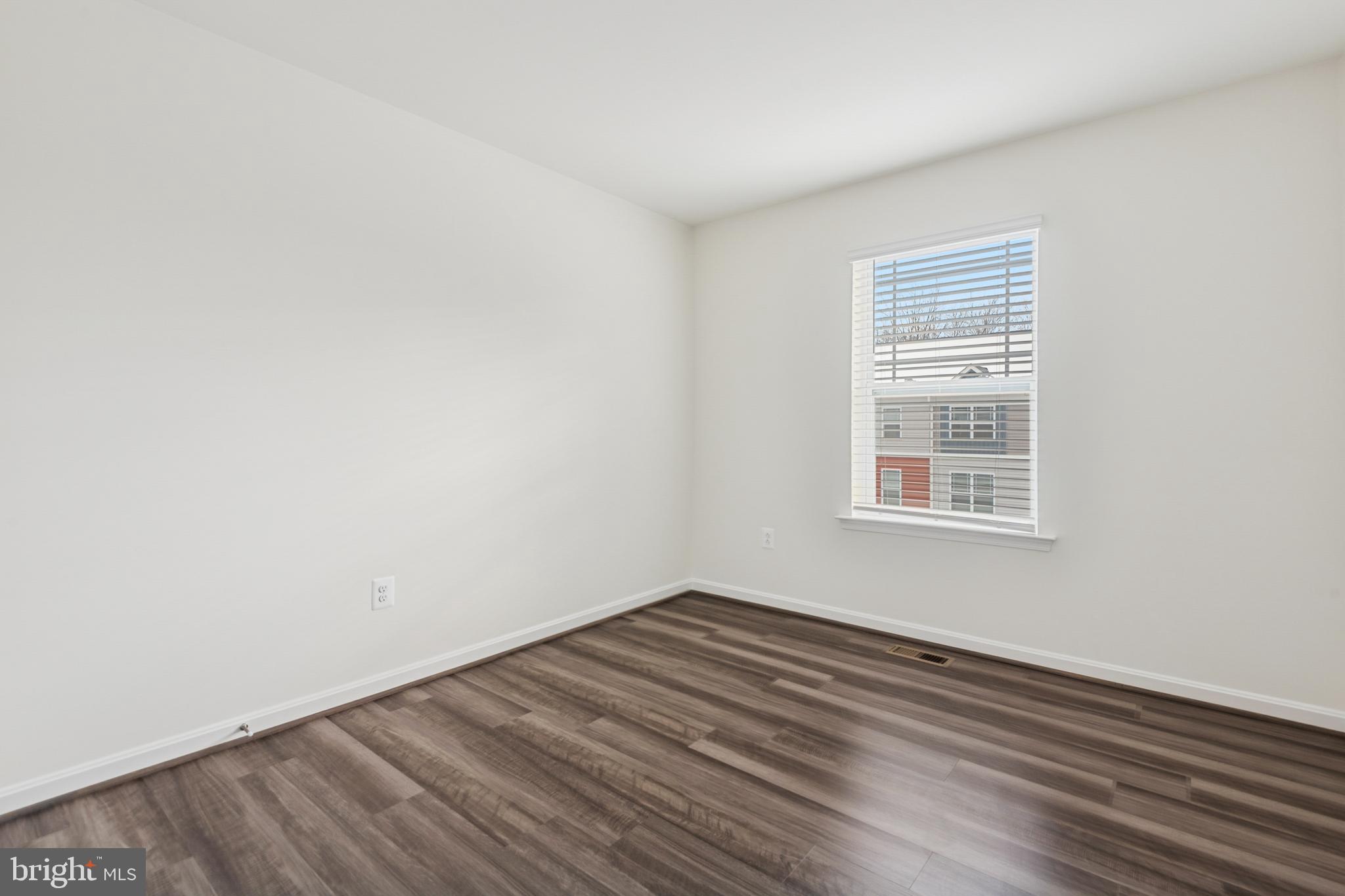 7831 Wolf Run Lane Severn, MD 21144 - Photo 24 of 30 an empty room with wooden floor and windows