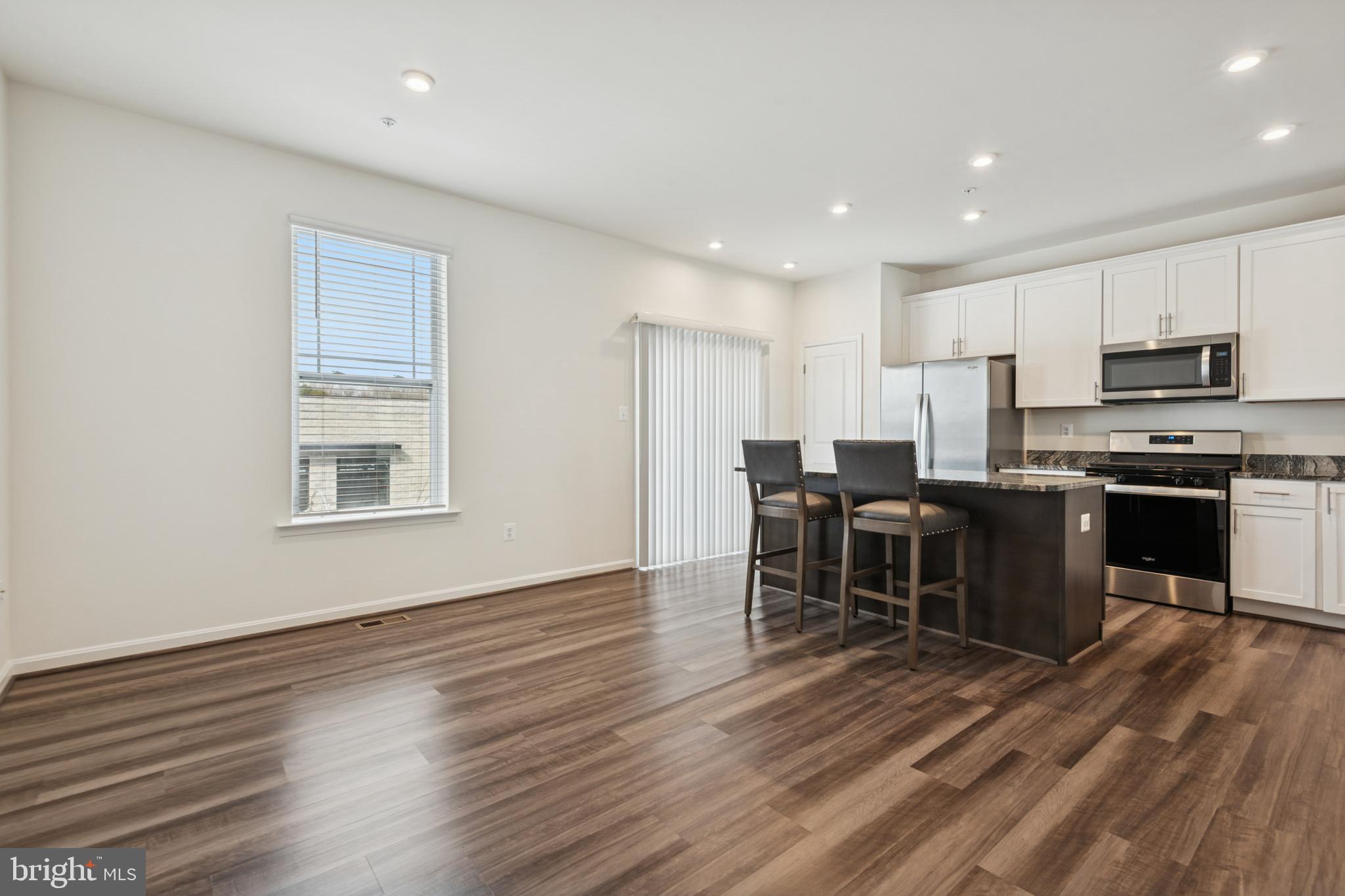 7831 Wolf Run Lane Severn, MD 21144 - Photo 6 of 30 a living room with stainless steel appliances kitchen island granite countertop furniture and wooden floors