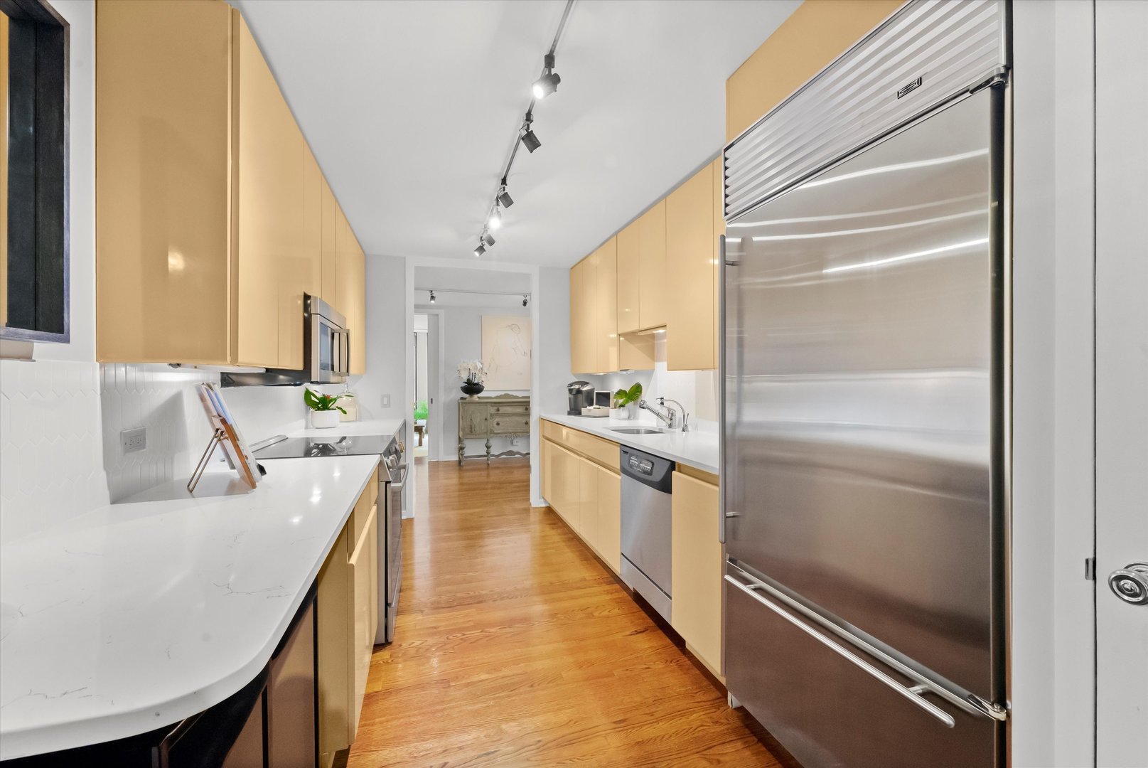 200 East Delaware Place, Unit 15F Chicago, IL 60611 - Photo 3 of 27 a large kitchen with kitchen island a large counter space a sink appliances and cabinets