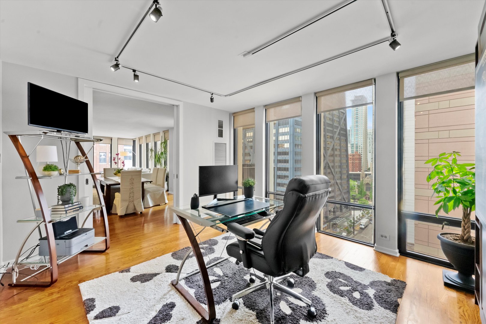 200 East Delaware Place, Unit 15F Chicago, IL 60611 - Photo 7 of 27 a workspace with furniture and a flat screen tv