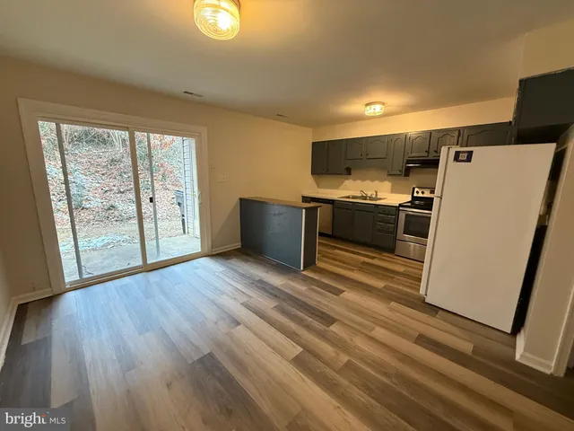 a kitchen with stainless steel appliances a refrigerator sink and wooden floor