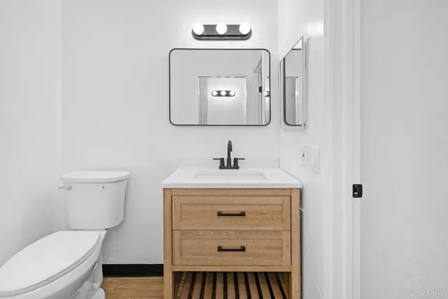 a bathroom with a toilet a sink and mirror