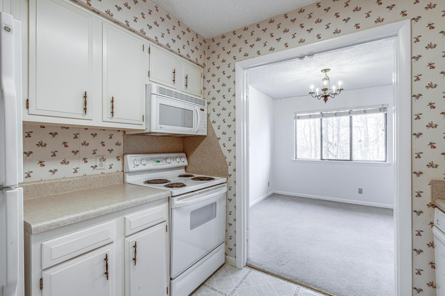 3086 Colony Road, Unit E Durham, NC 27705 - Photo 7 of 30 a kitchen with granite countertop a stove a sink and dishwasher with white cabinets