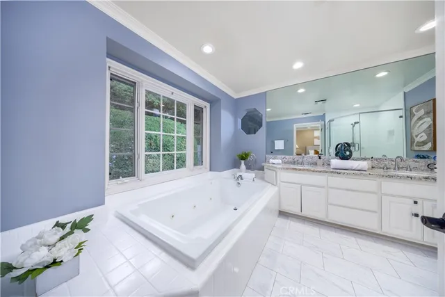 a large bathroom with a tub sink and mirror
