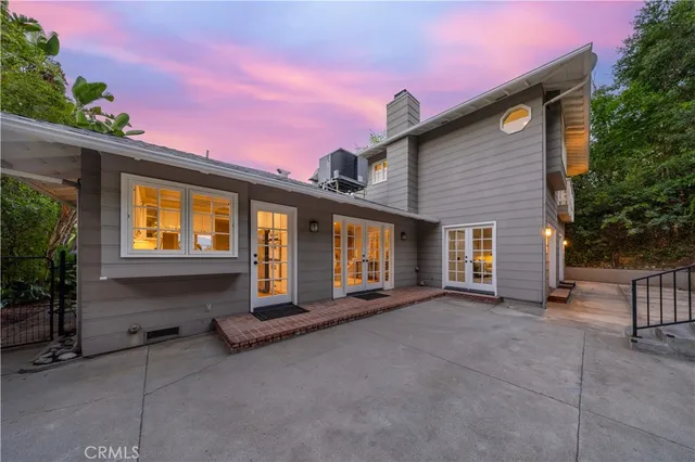 a front view of a house with yard and mountain view in the back