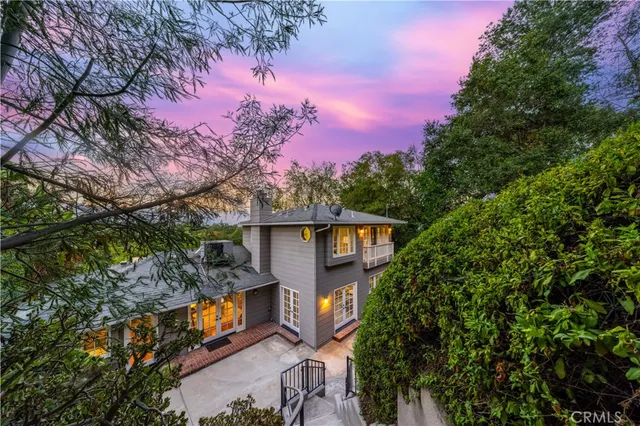 a front view of a house with yard and trees