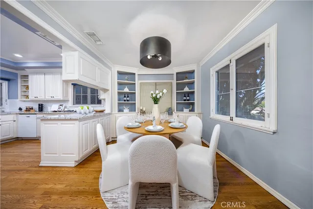 a dining room with wooden floor and stainless steel appliances