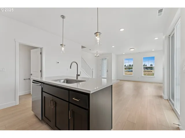 a kitchen with a sink a counter space and wooden floor