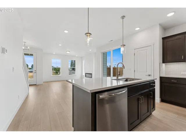 a kitchen with stainless steel appliances granite countertop a sink a stove and a refrigerator