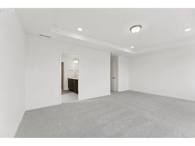 a view of a big room with wooden floor and windows