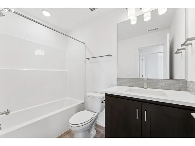 a bathroom with a sink a toilet a mirror and shower