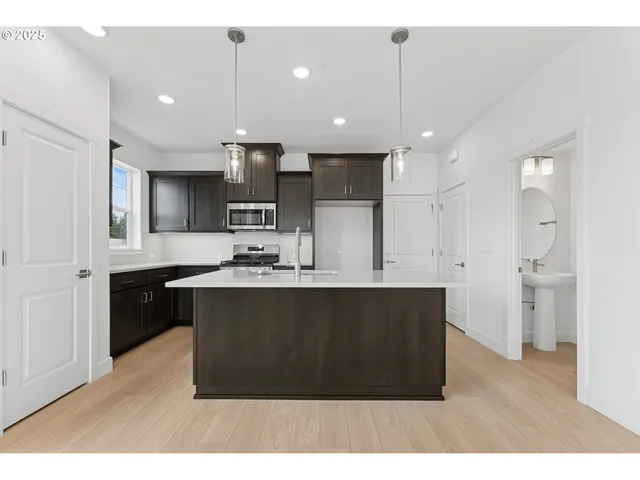 a kitchen with kitchen island a sink stainless steel appliances and cabinets