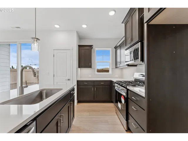 a kitchen with granite countertop a sink stove and refrigerator