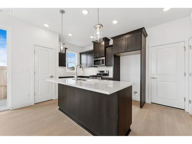 a kitchen with kitchen island a sink stainless steel appliances and cabinets