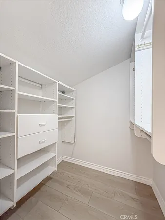 a bedroom with a bed and a wooden floor