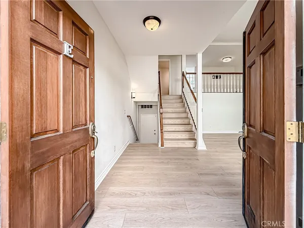 a view of a hallway with wooden floor and staircase